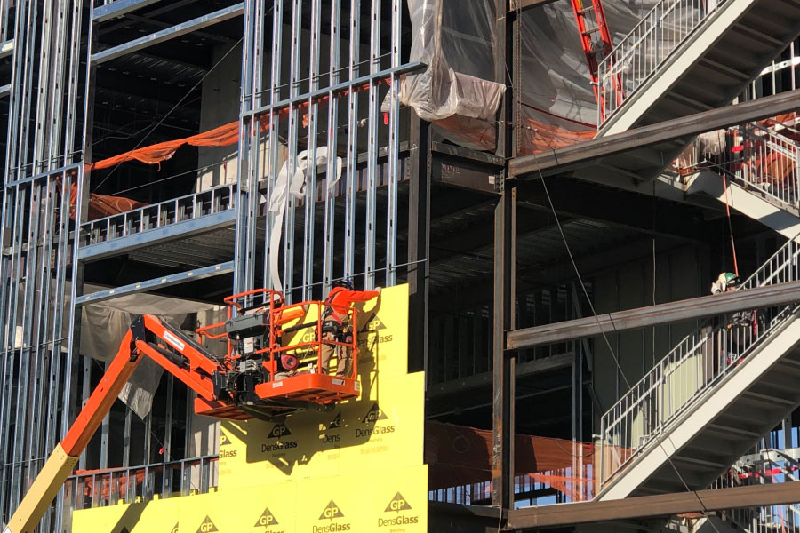 Picture of a construction jobsite where worker is installing the exterior wall insulation | Labor shortage | Knowify