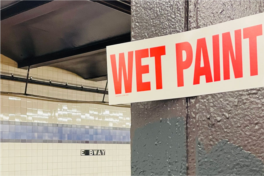 Picture of a 'WET PAINT' sign in a subway station | How to estimate a painting job | Knowify